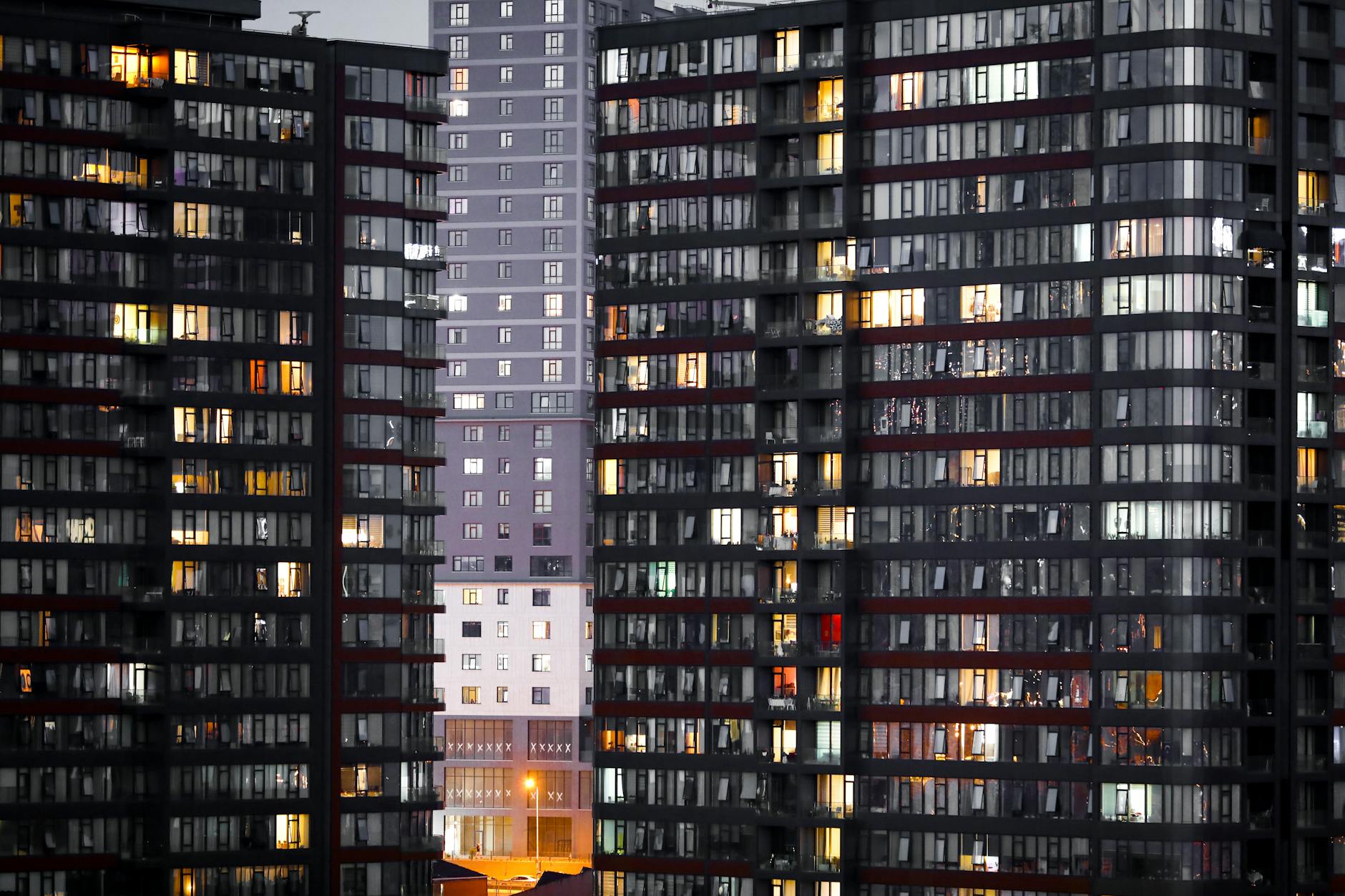 Illuminated high-rise residential buildings with glass facades at twilight