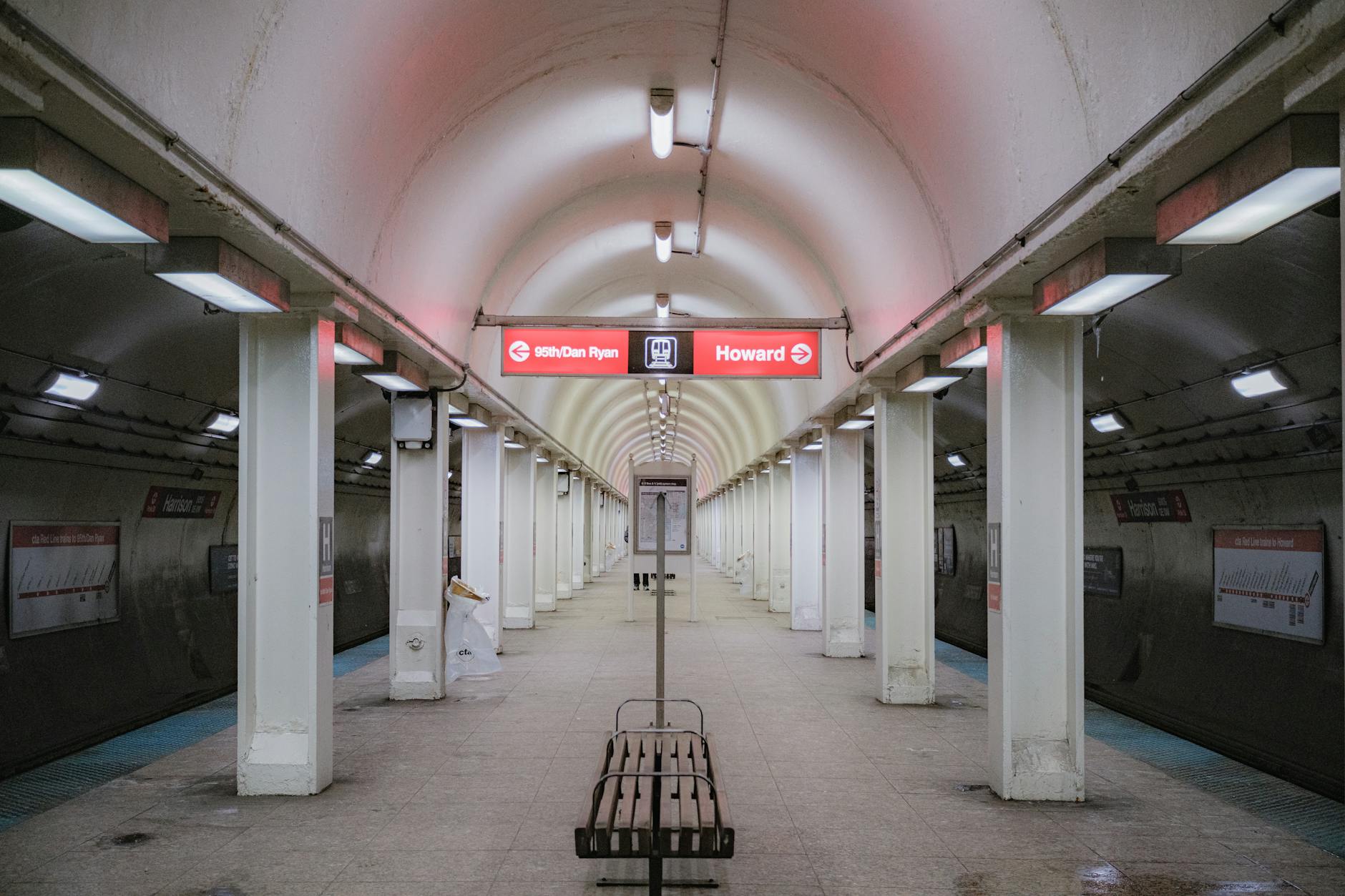 An empty subway station platform with curved ceiling lighting