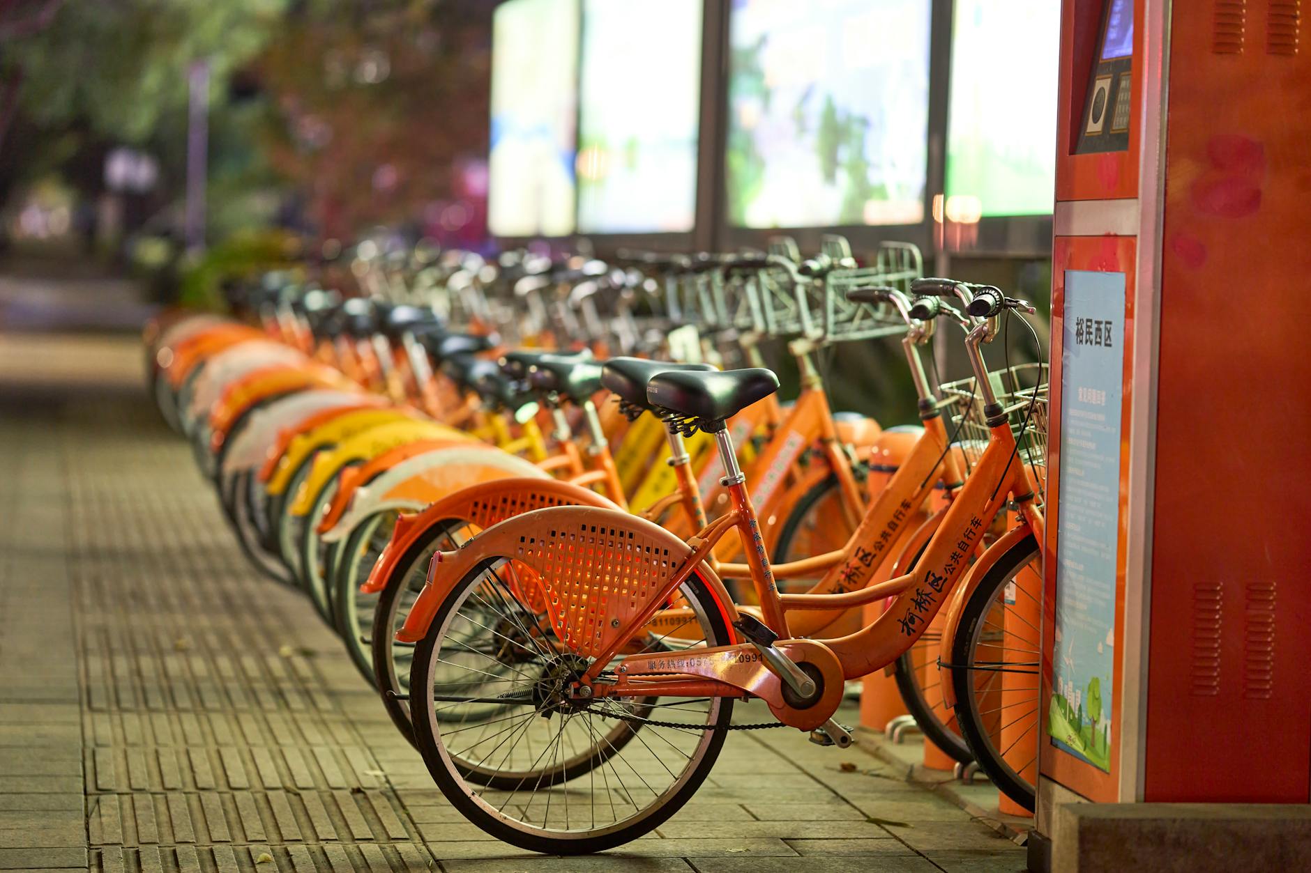 A line of rental bicycles parked at an outdoor bike-share station