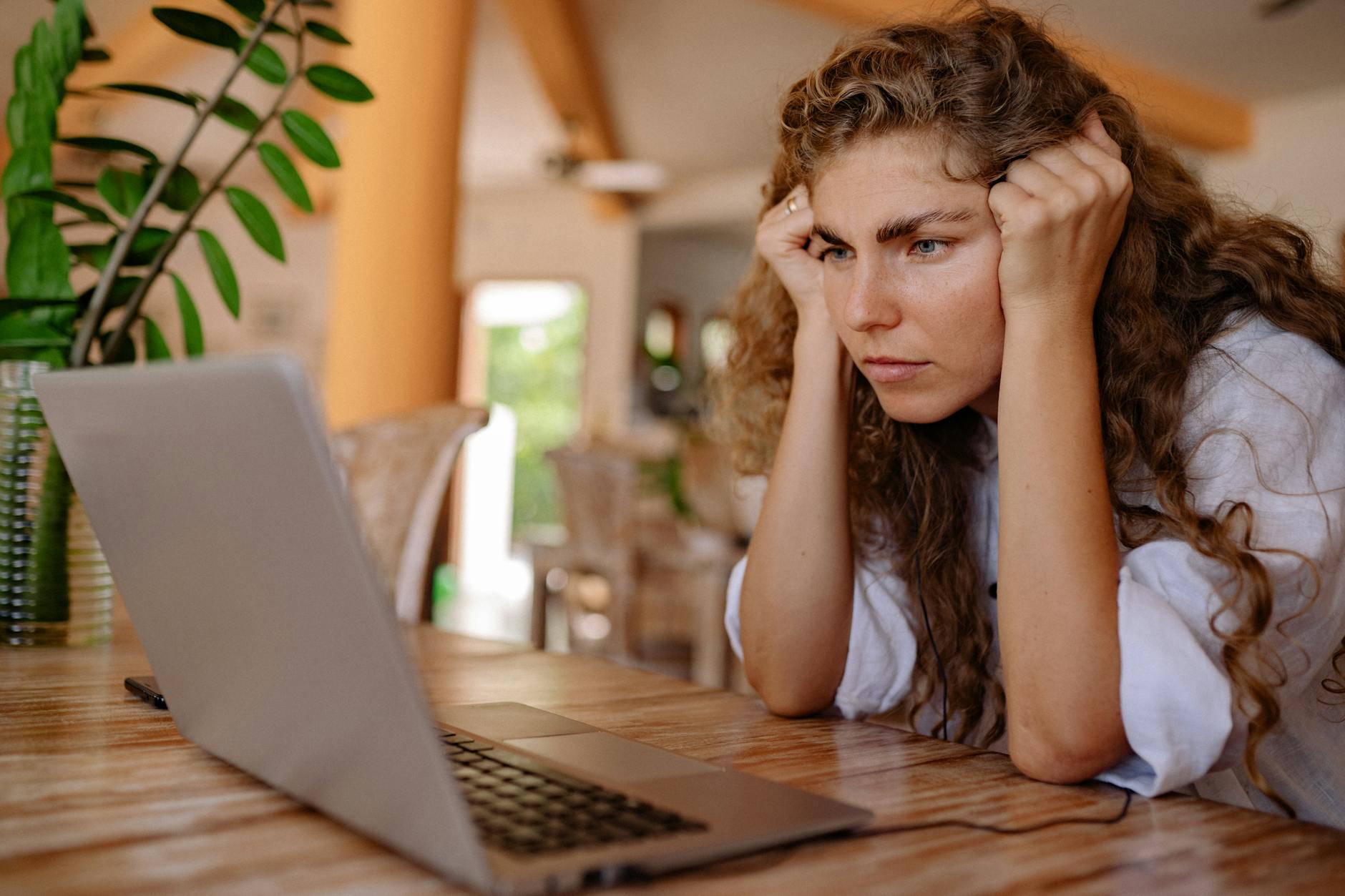 A person focused on a laptop screen while reviewing a listing