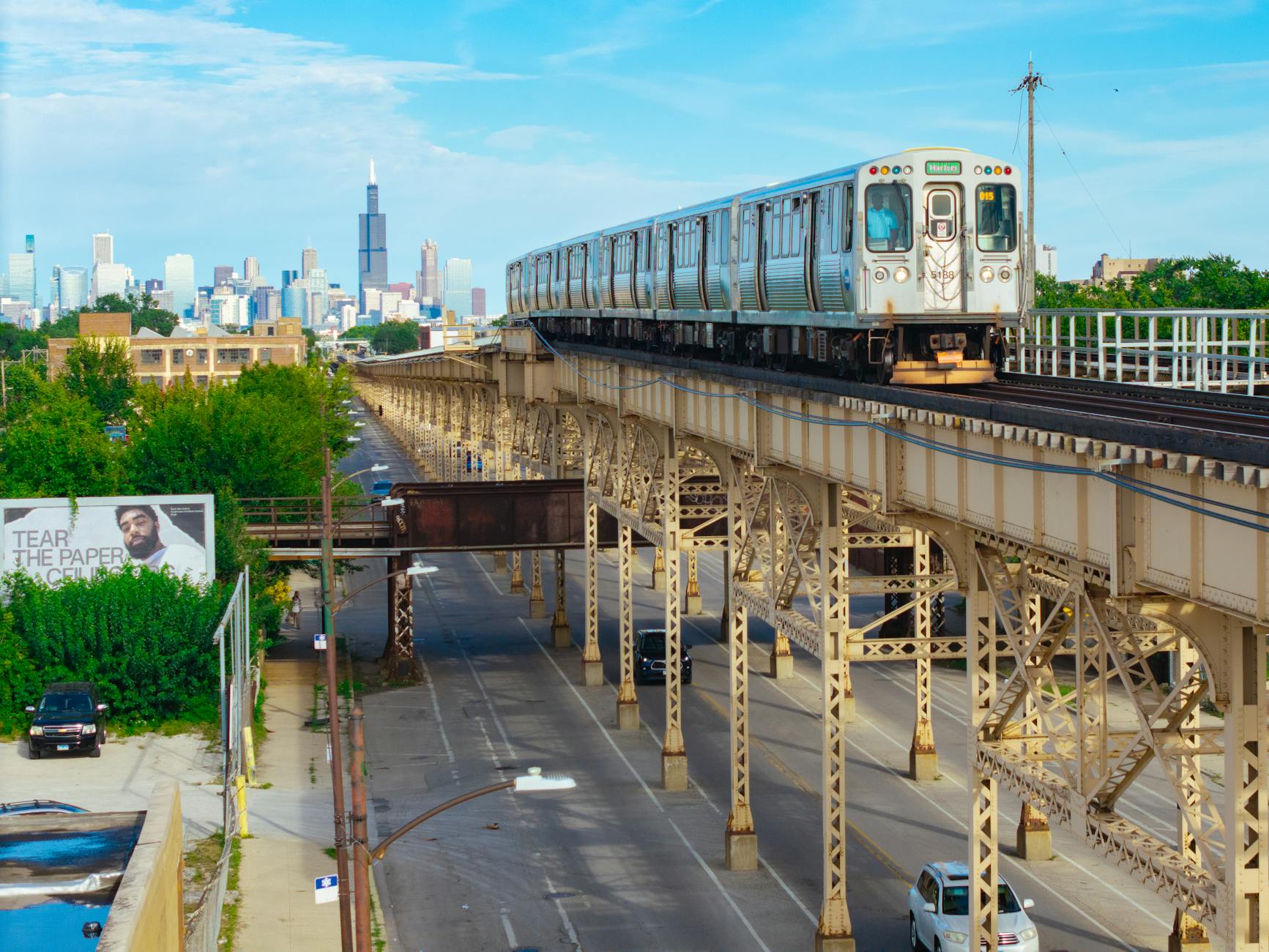 An elevated CTA L train with the Chicago skyline and the Willis Tower