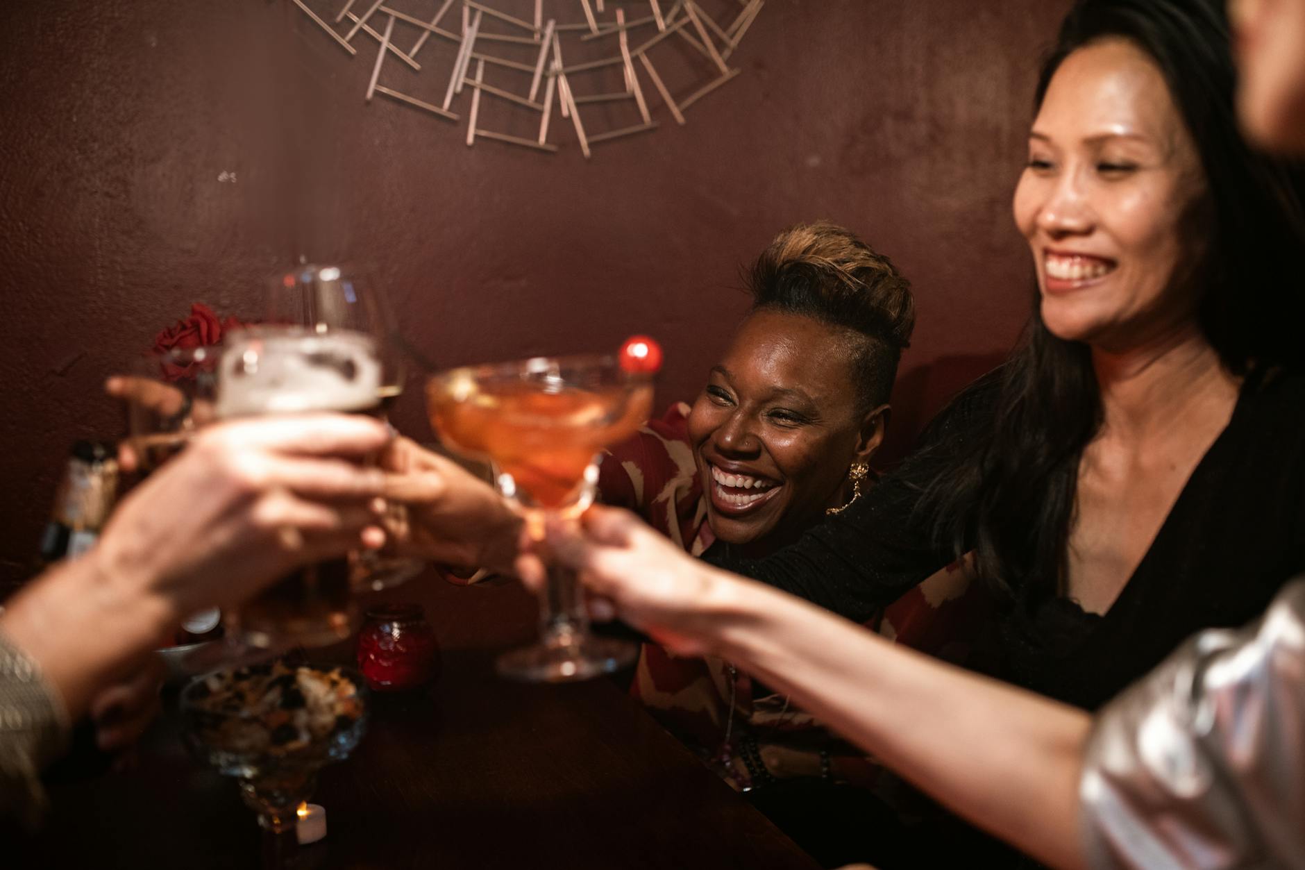 A cheerful group of friends toasting with drinks at a bar
