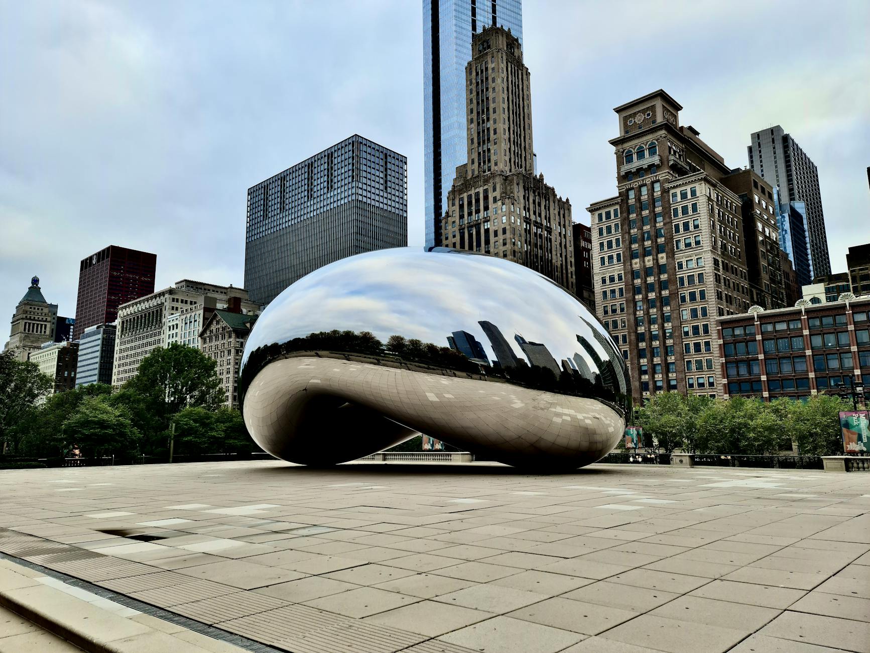 The reflective Cloud Gate sculpture in Chicago surrounded by skyscrapers