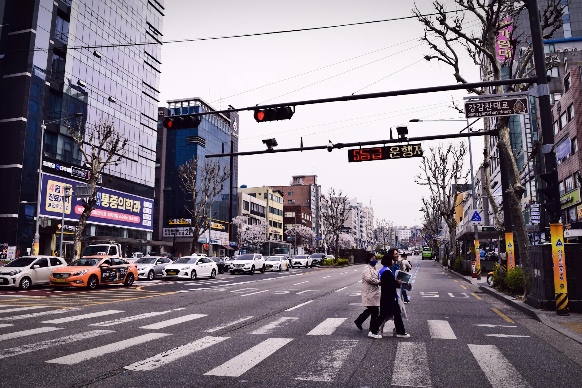 Pedestrians crossing a busy downtown street