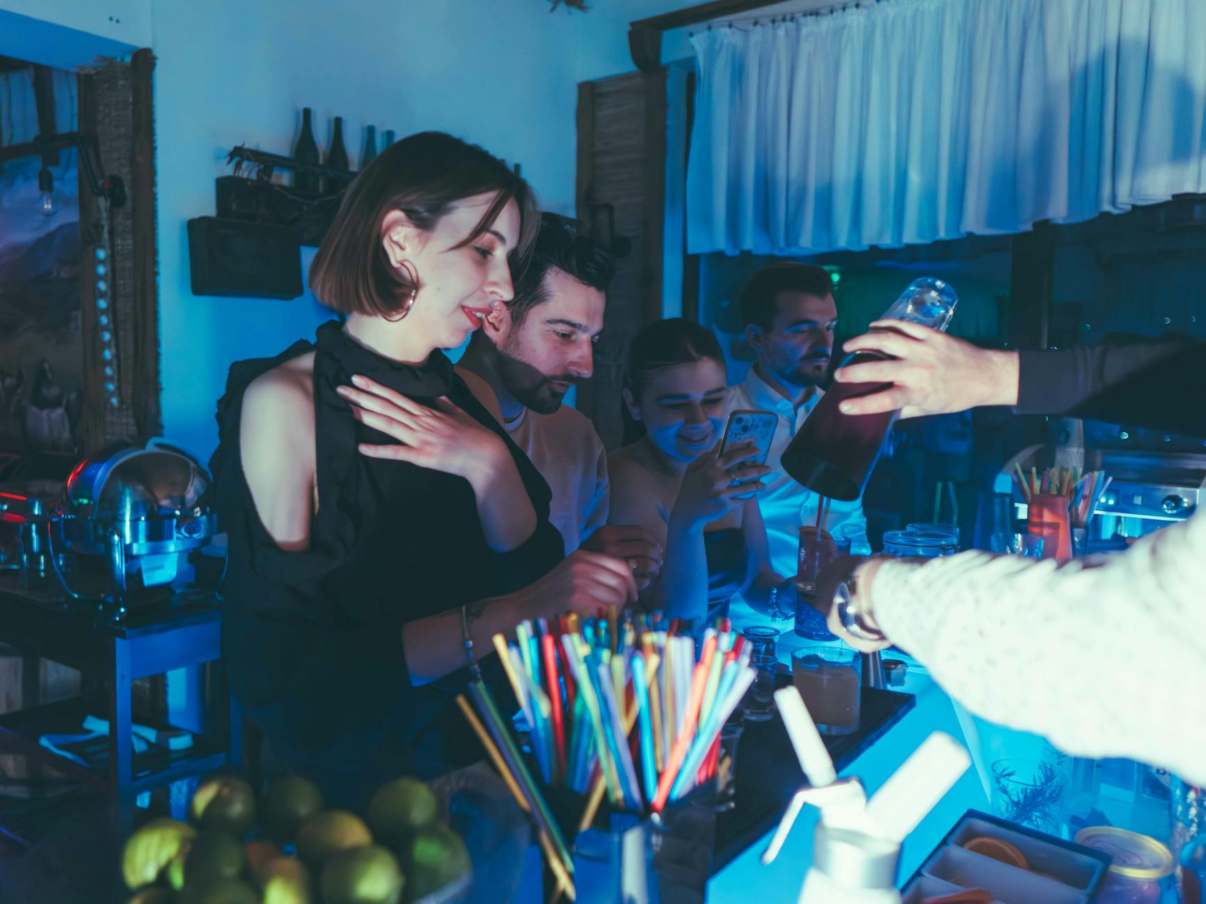 Friends enjoying drinks at a lively bar in the evening