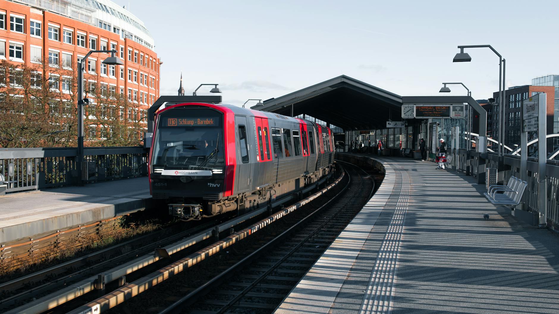 A train arriving at an outdoor city station platform