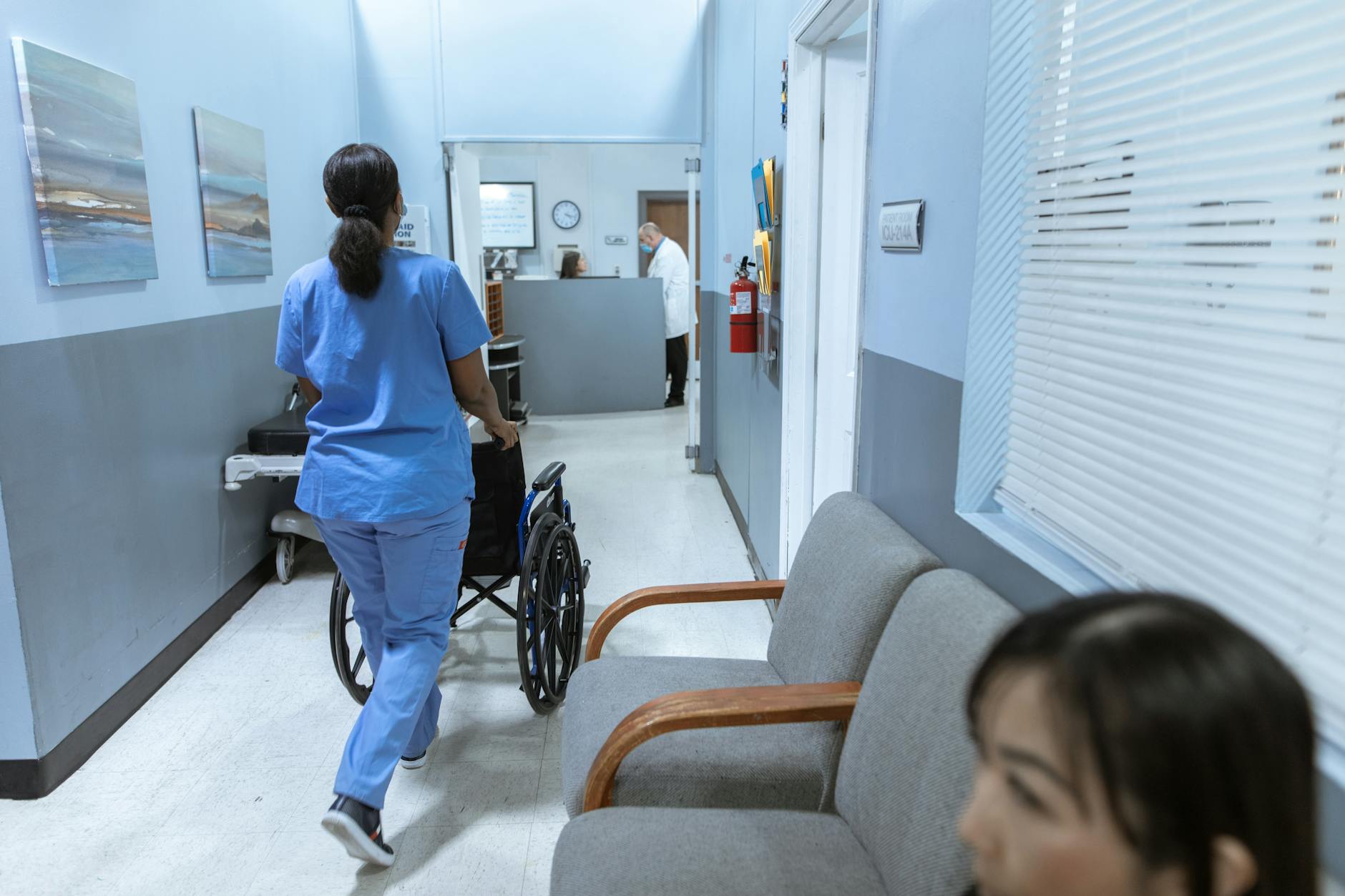 A nurse in scrubs walking through a hospital corridor