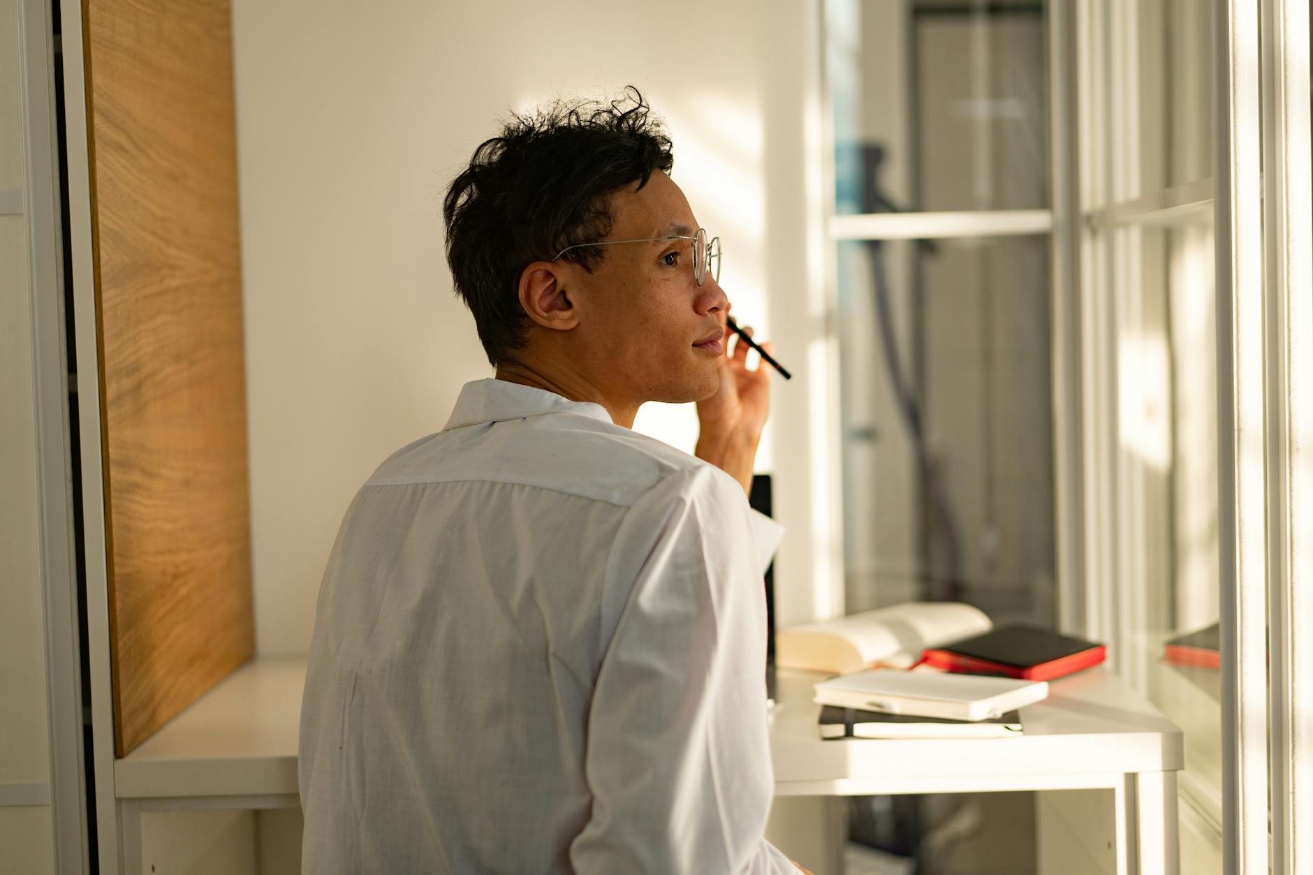 A person looking thoughtfully out a window