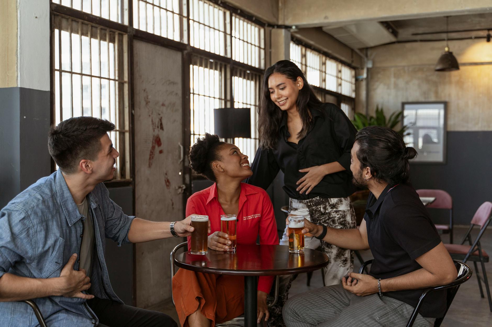 A group of friends sharing drinks and laughing at a cafe