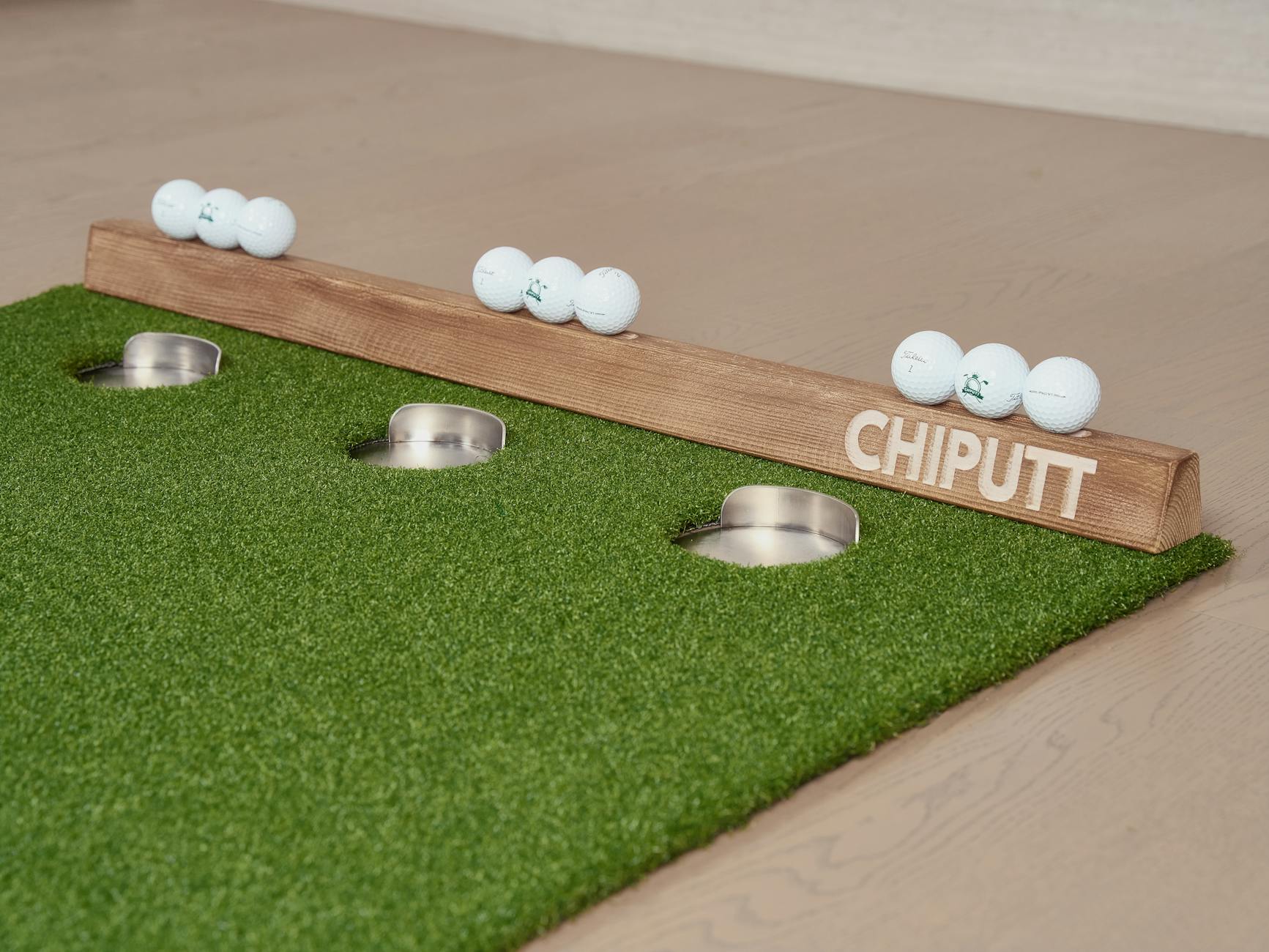 An indoor golf putting setup with balls and holes