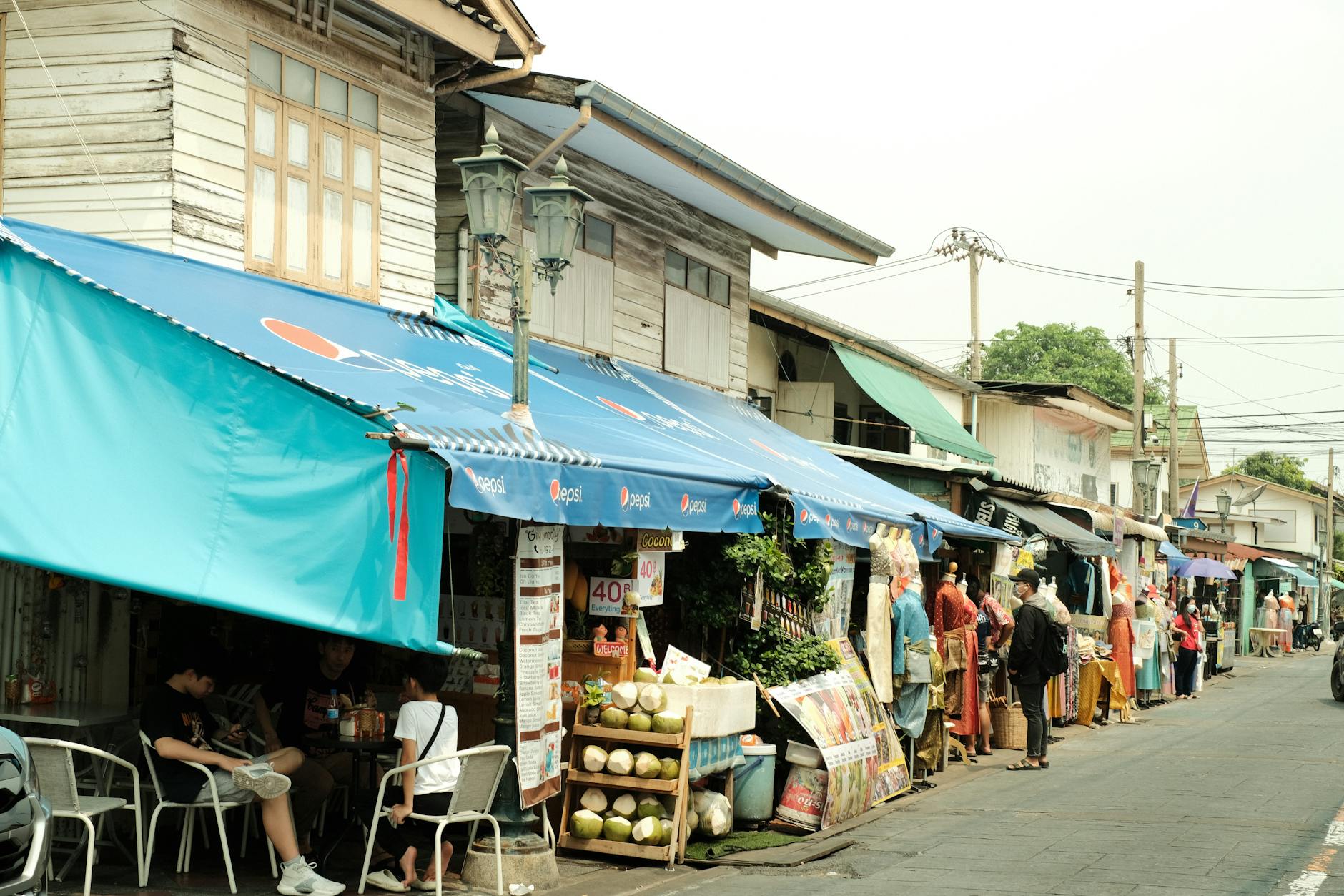 A lively neighborhood market street with stalls and shoppers