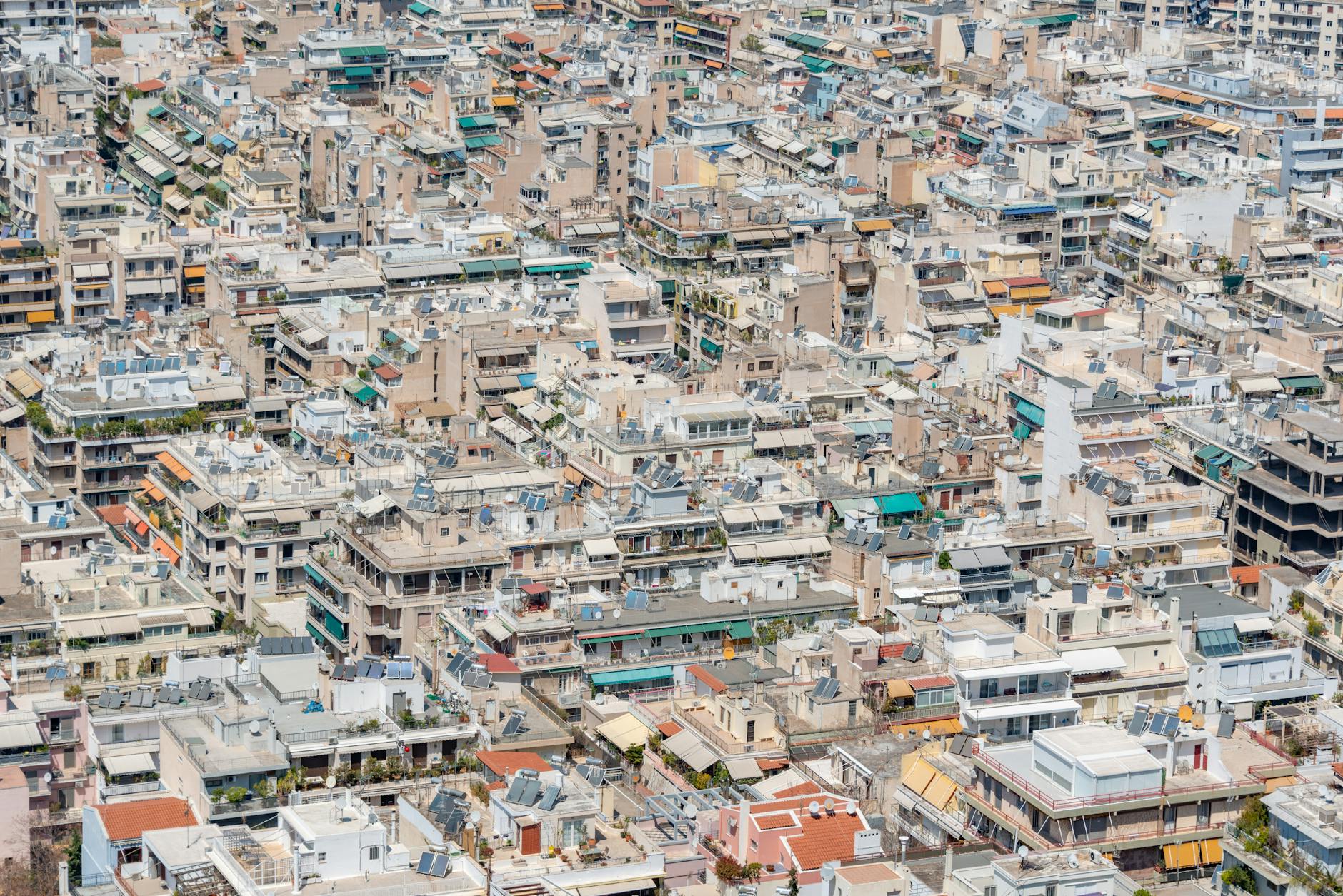 An aerial view of a dense city of rooftops and buildings