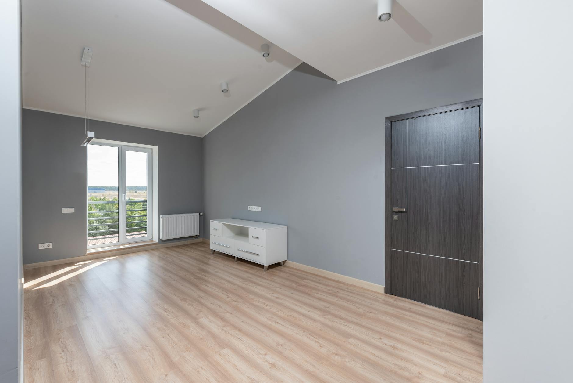 A bright, modern apartment interior with hardwood floors and large windows