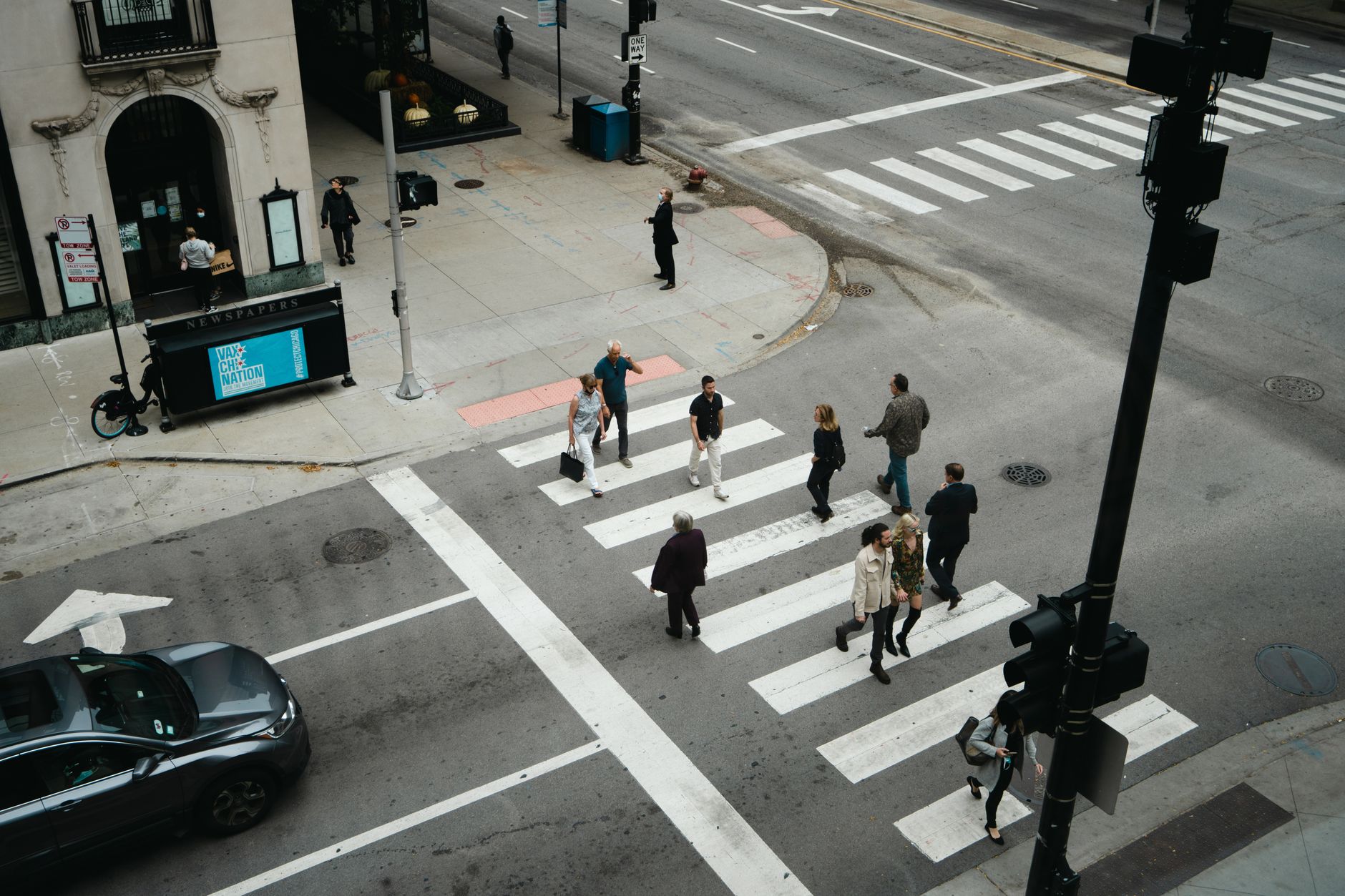 Aerial view of people crossing a city street at a pedestrian crosswalk