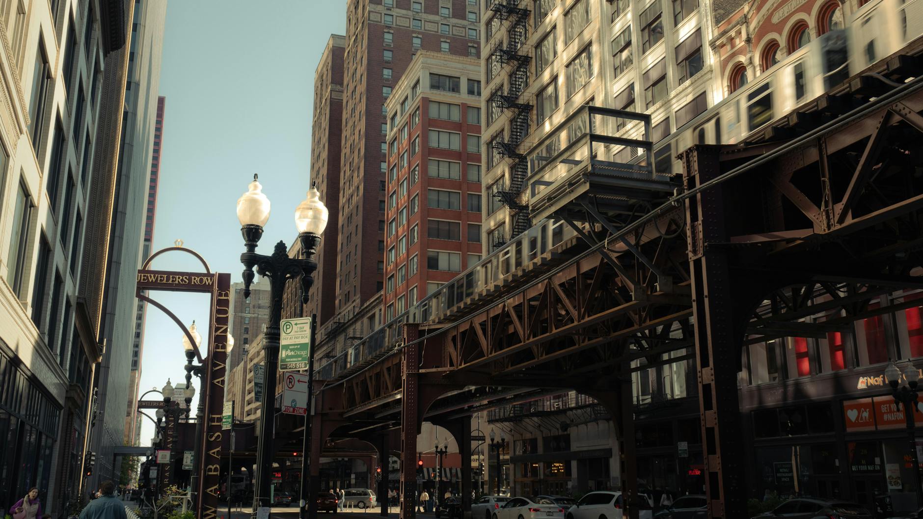 An elevated CTA train running through Chicago's West Loop on a sunny day